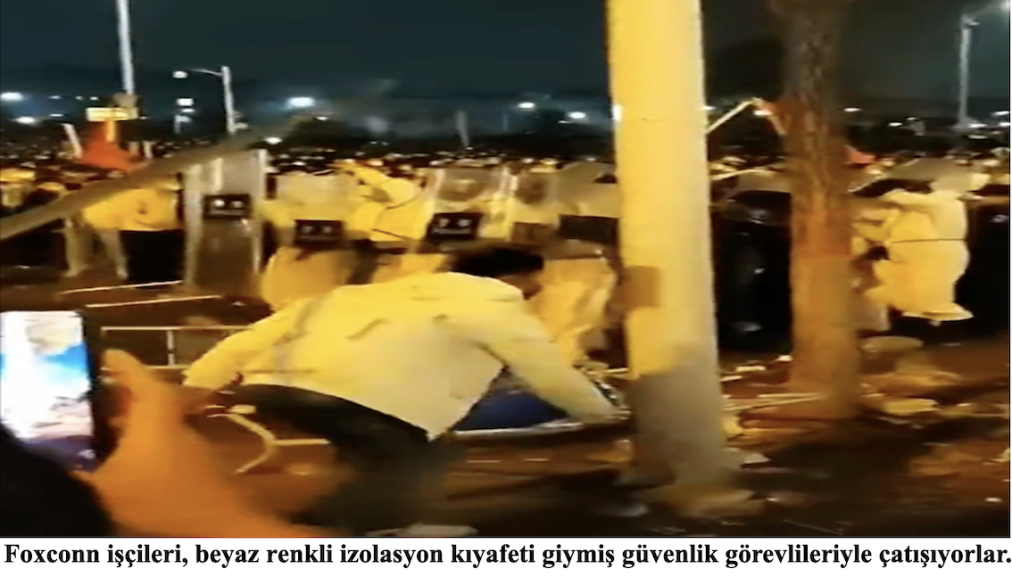 Foxconn işçileri, beyaz renkli izolasyon kıyafeti giymiş güvenlik görevlileriyle çatışıyorlar.